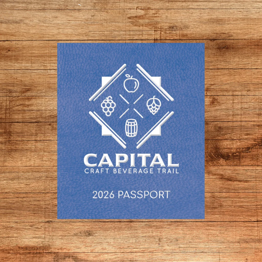 Blue 2026 Capital Craft Beverage Trail passport on a wooden table
