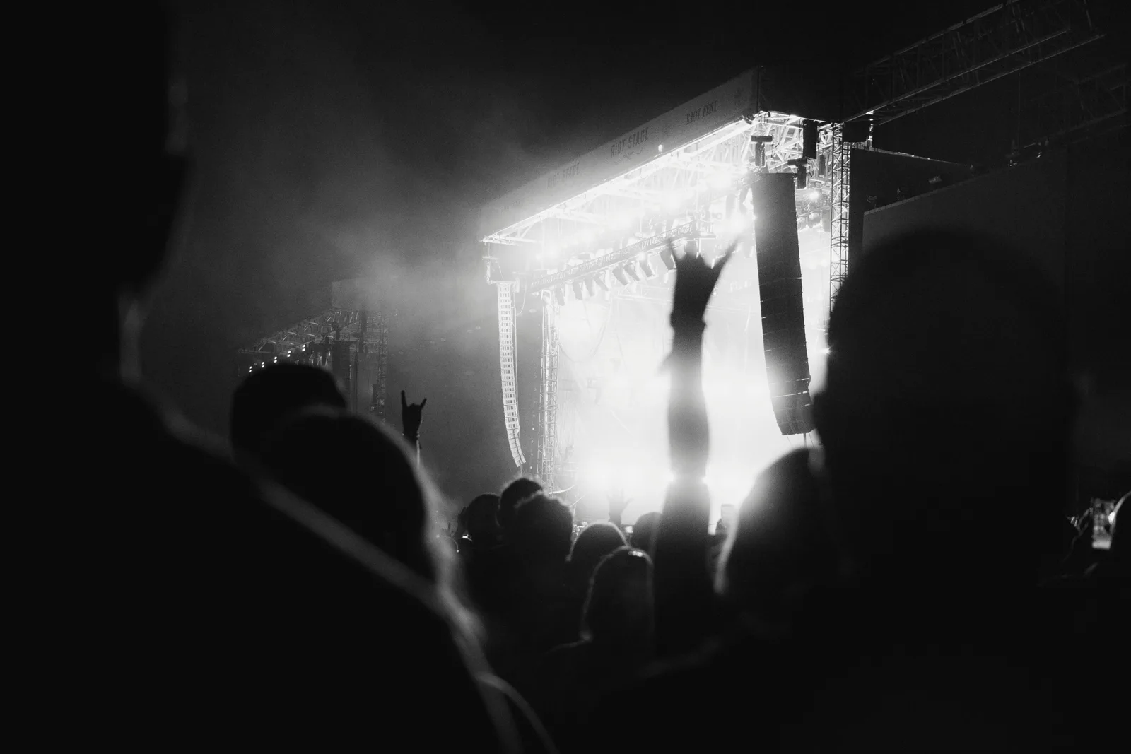 A concert crowd facing a brightly lit stage