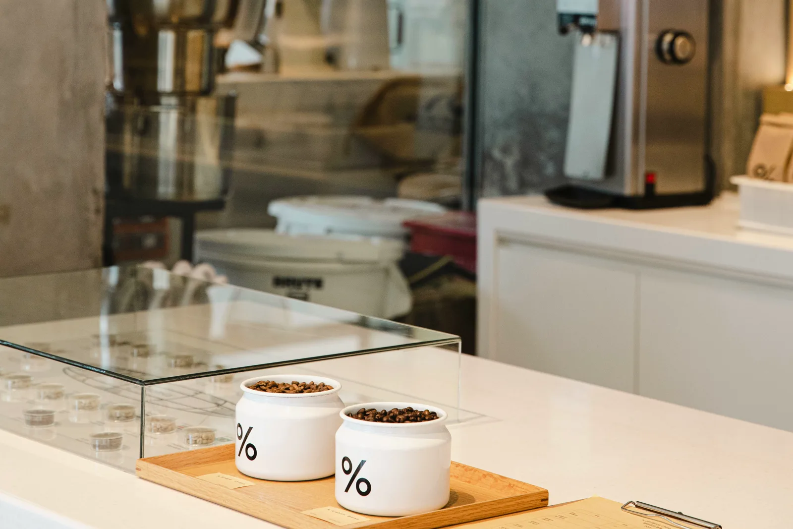A quiet coffee counter with two percentage-marked jars beside the till