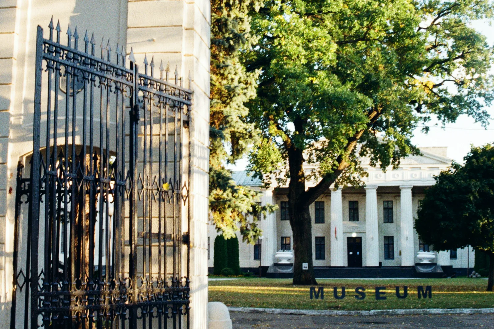 A museum entrance framed by an open iron gate